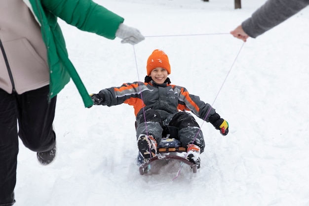 Ragazzo sorridente sull'orario invernale della slitta