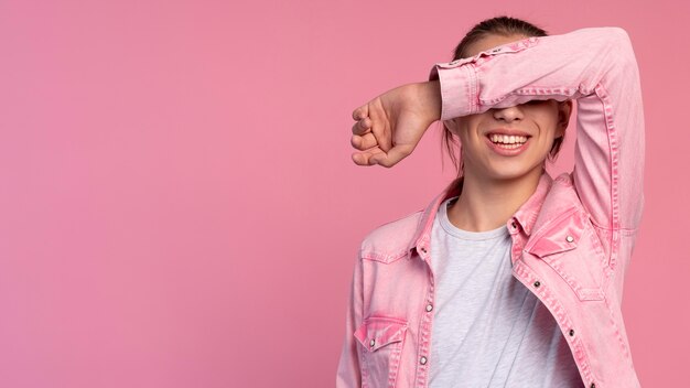 Ragazzo teenager alla moda nella posa rosa con lo spazio della copia
