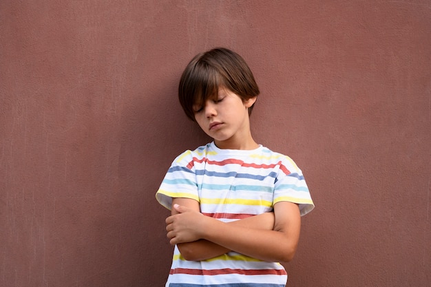 Ragazzo triste di vista frontale vicino al muro