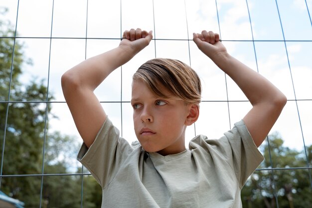 Ragazzo triste di vista frontale vicino al recinto