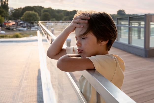 Ragazzo triste di vista laterale all'aperto