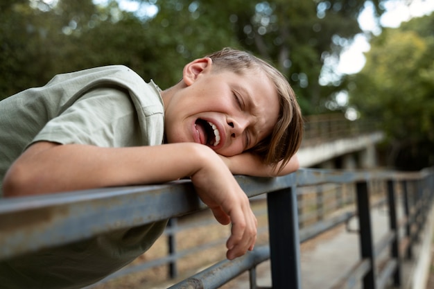 Ragazzo triste di vista laterale che piange all'aperto