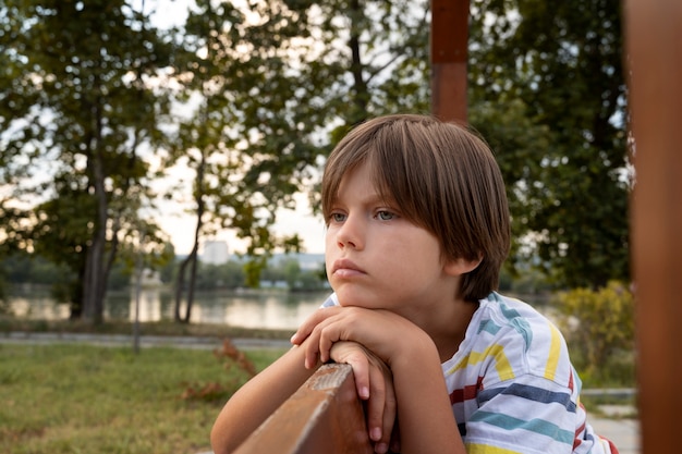 Ragazzo triste sulla vista laterale della panchina