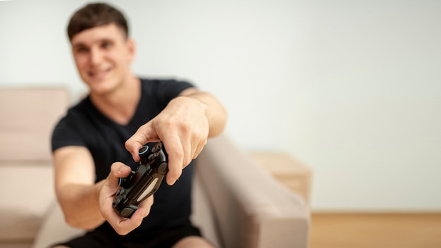 Ragazzo vago vista frontale che gioca con un controller