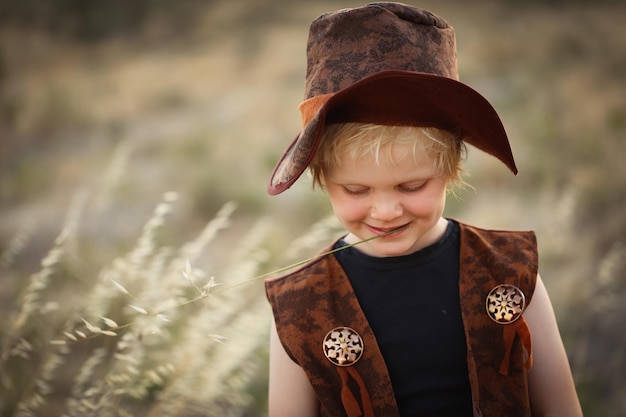 Ragazzo vestito da cowboy in un ambiente naturale all'aperto