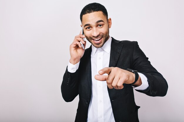 Raggiungendo un grande successo nella carriera di bel giovane in camicia bianca, giacca nera, parlando al telefono. Elegante uomo d'affari, sorridente, che esprime felicità, buona fortuna.