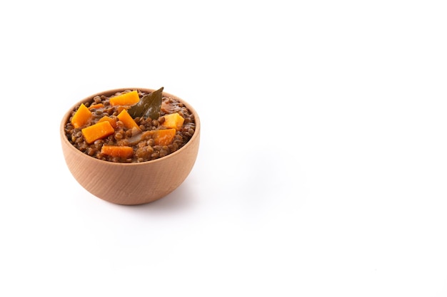 Ragù di stufato di lenticchie con zucca e carote in una ciotola isolata su sfondo bianco