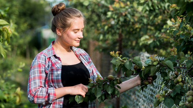 Ramo di albero della tenuta della ragazza di vista laterale