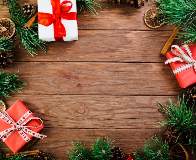 Ramoscelli e scatole di Natale sul bordo di legno
