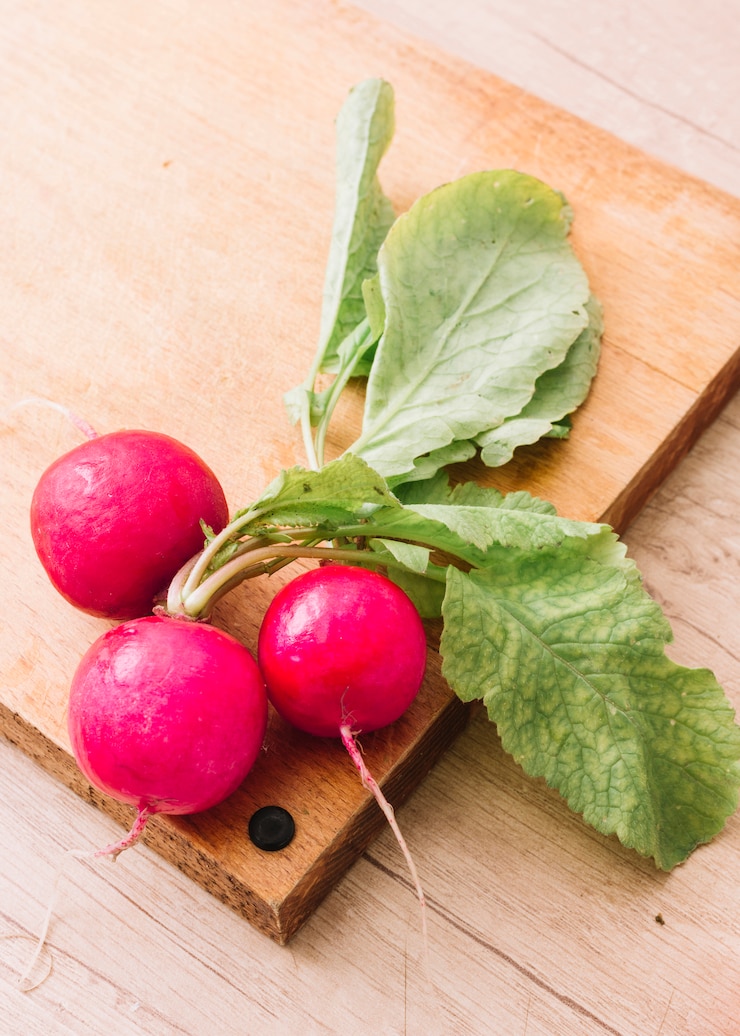 Foto gratuito rape organiche rosa fresche sul tagliere