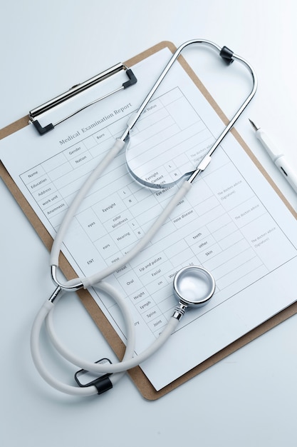 Rapporto di esame medico e stetoscopio sul desktop bianco
