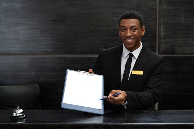 Receptionist maschio in abito elegante durante l'orario di lavoro