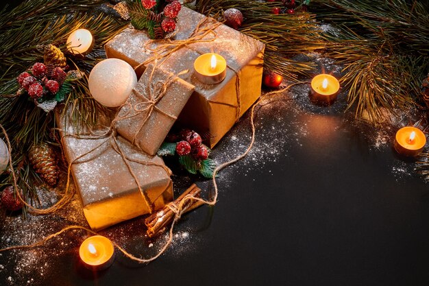 Regali di Natale, albero di natale, candele, decorazioni colorate, stelle, palline su sfondo nero