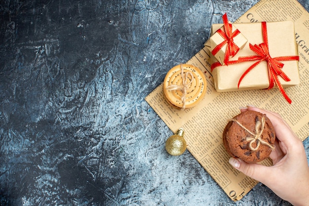 Regali di Natale vista dall'alto con biscotti e giocattoli su sfondo chiaro-scuro