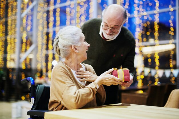 Regalo di Natale come sorpresa per la moglie, felice coppia senior