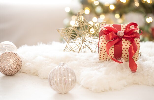 Regalo di Natale con decorazioni sull'albero su uno spazio di copia di sfondo bokeh sfocato chiaro.