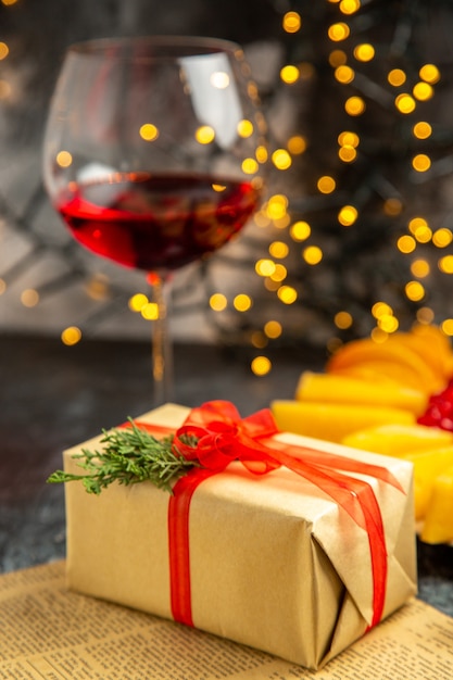 Regalo di Natale di vetro di vino vista frontale su luci di Natale scure