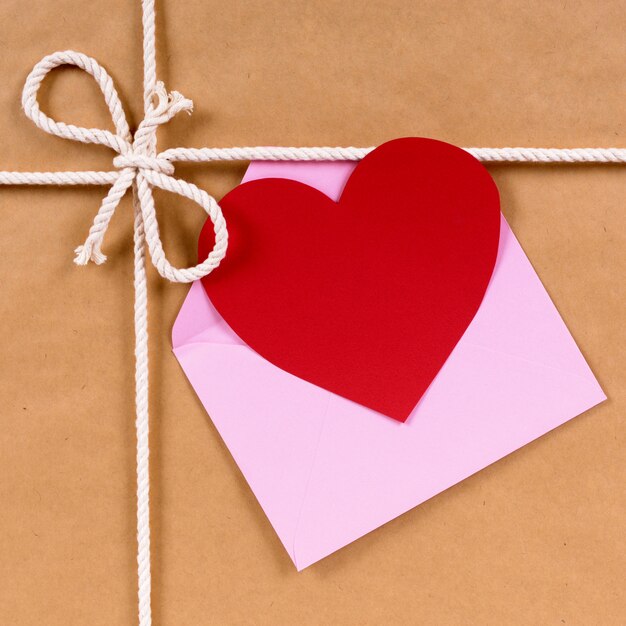 Regalo di San Valentino con carta a forma di cuore o etichetta regalo, pacchetto di carta marrone