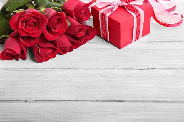 regalo di San Valentino e le rose rosse su fondo bianco tavola di legno