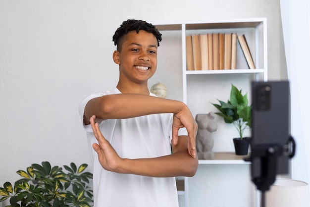 Registrazione del ragazzo di smiley di vista frontale con il telefono