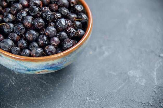 Ribes nero a metà vista inferiore in una ciotola su superficie scura