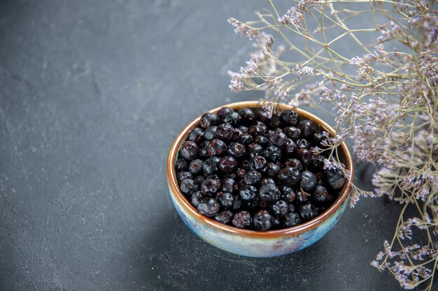 Ribes nero di vista dal basso in ciotola sul posto libero di superficie isolato