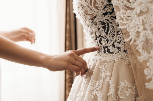 Ricamo sul bellissimo abito da sposa, preparazione per la cerimonia nuziale, abito di alta moda fatto a mano