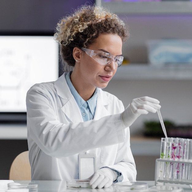 Ricercatore femminile in laboratorio con occhiali di sicurezza e provette