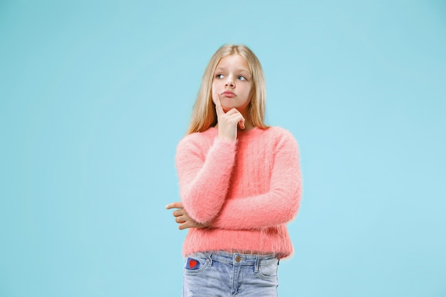 Ricorda tutto. Fammi pensare. Concetto di dubbio. Ragazza teenager dubbiosa e premurosa che ricorda qualcosa. Giovane bambino emotivo. Emozioni umane, concetto di espressione facciale. Studio. Isolato sul blu alla moda