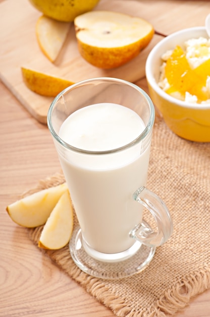 Ricotta con marmellata di pere in una ciotola e un bicchiere di latte