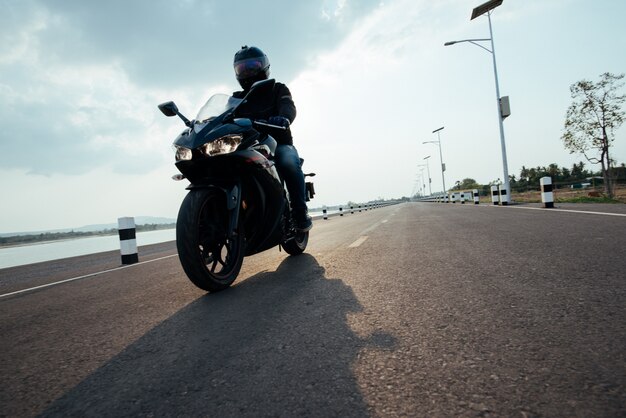 Rider Motorbike sulla guida su strada. divertendosi guidando la strada vuota