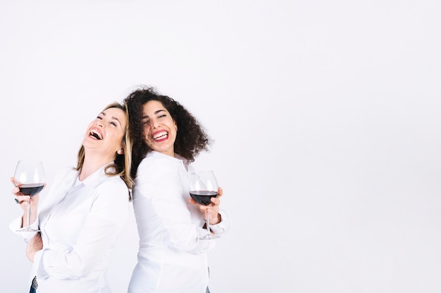 Ridere le donne con bicchieri da vino