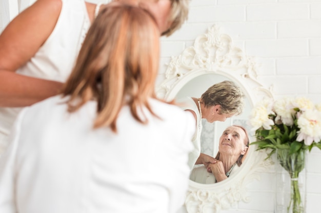 Riflessione di madre e figlia sullo specchio a casa
