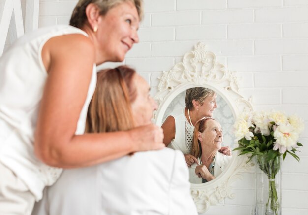 Riflessione di madre e figlia sullo specchio guardando lontano