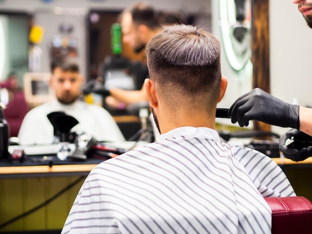 Riflessione di specchio vaga del cliente nel negozio di barbiere