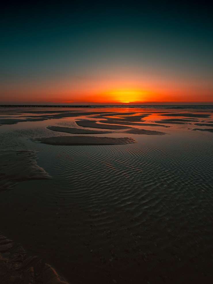 Foto gratuito riflesso del tramonto nell'oceano catturato a domburg, paesi bassi