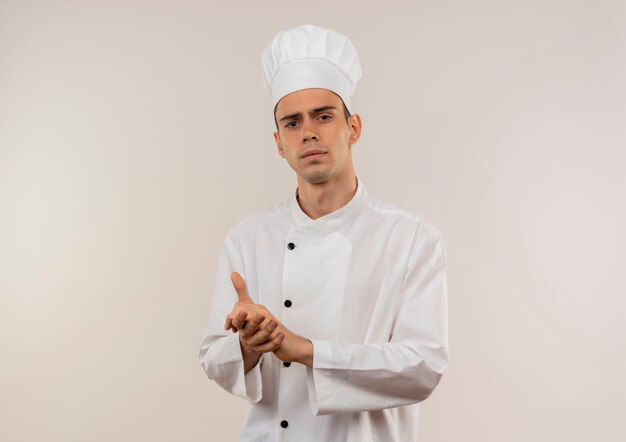 Rigoroso giovane cuoco maschio che indossa l'uniforme del cuoco unico che mostra il gesto della stretta di mano