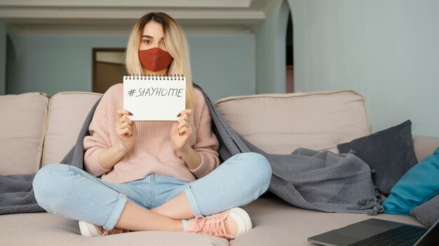 Rimanere in casa donna che indossa maschera medica rossa