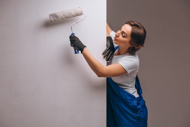 Riparatore della donna con il rullo di pittura isolato