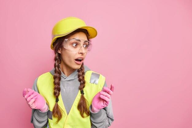 Riparazione e concetto di costruzione. La donna sorpresa perplessa allarga le mani distoglie lo sguardo