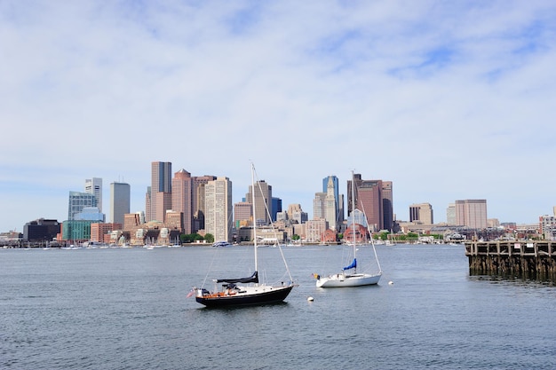 Riposo in barca a vela con molo nella baia e skyline del centro di Boston con grattacieli urbani sul mare al mattino.