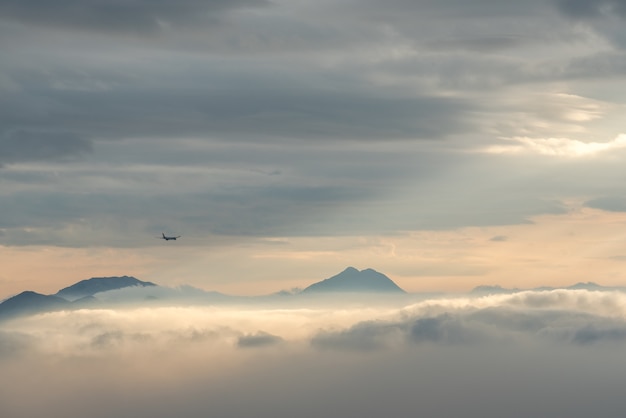 Ripresa ad alto angolo delle bellissime cime montuose visibili attraverso le nuvole e la nebbia