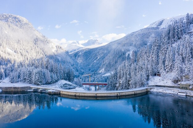 Ripresa aerea delle montagne innevate con un lago calmo di giorno