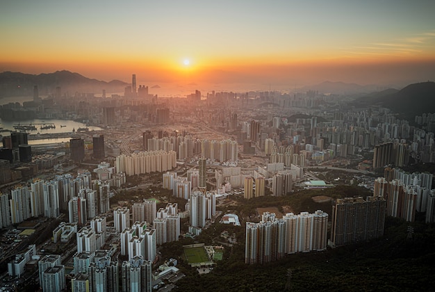 Ripresa aerea dello skyline della città sotto un cielo arancione al tramonto