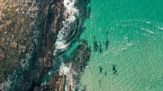 Ripresa aerea di scogliere rocciose vicino a un paesaggio marino turchese