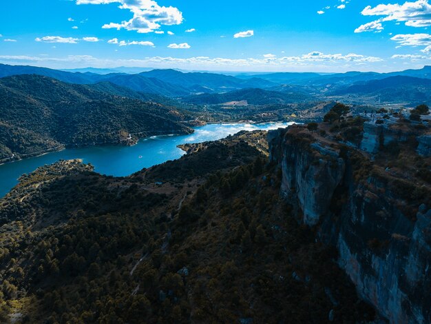 Ripresa aerea di un lago in cima alla montagna con cielo blu sullo sfondo