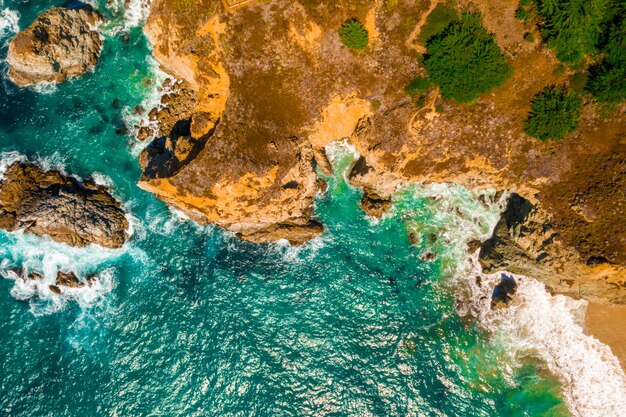 Ripresa aerea di un mare ondulato contro le scogliere di giorno