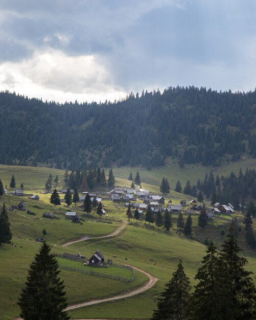 Ripresa aerea di un piccolo villaggio in un incredibile paesaggio di montagna in Transilvania, Romania