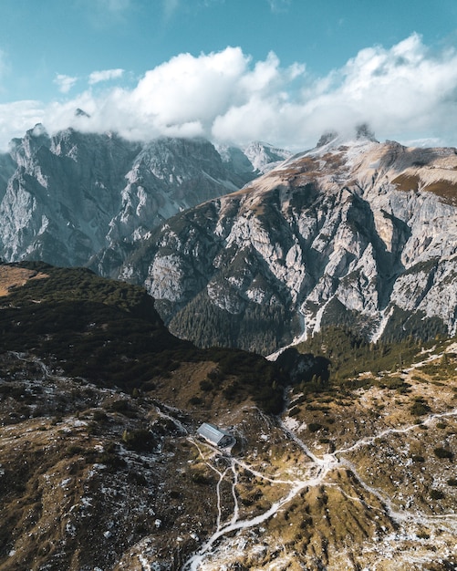 Ripresa aerea verticale di montagne sotto il cielo blu e nuvole bianche