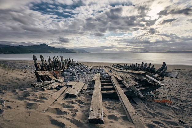 Ripresa panoramica di una barca naufragata sulla riva di Rossbeigh strand